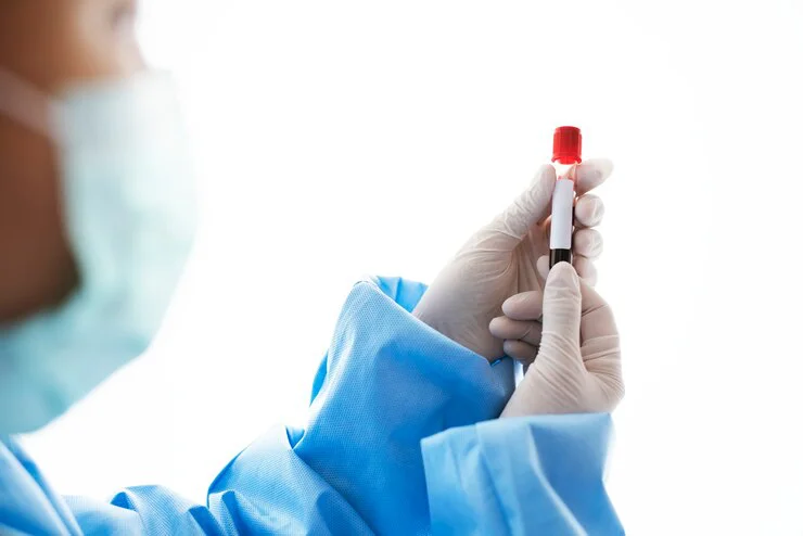 Doctor sostentiendo una muestra de sangre en un tubo de ensayo